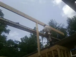 Carpenter setting a ridge beam over a new addition frame — Ice Dam Removal by Roofing Brothers in Le Sueur