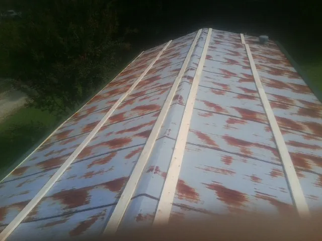 Rusted metal roof panels with new wood purlins before replacement — Storm Damage Roof Repair in Le Sueur by Roofing Brothers