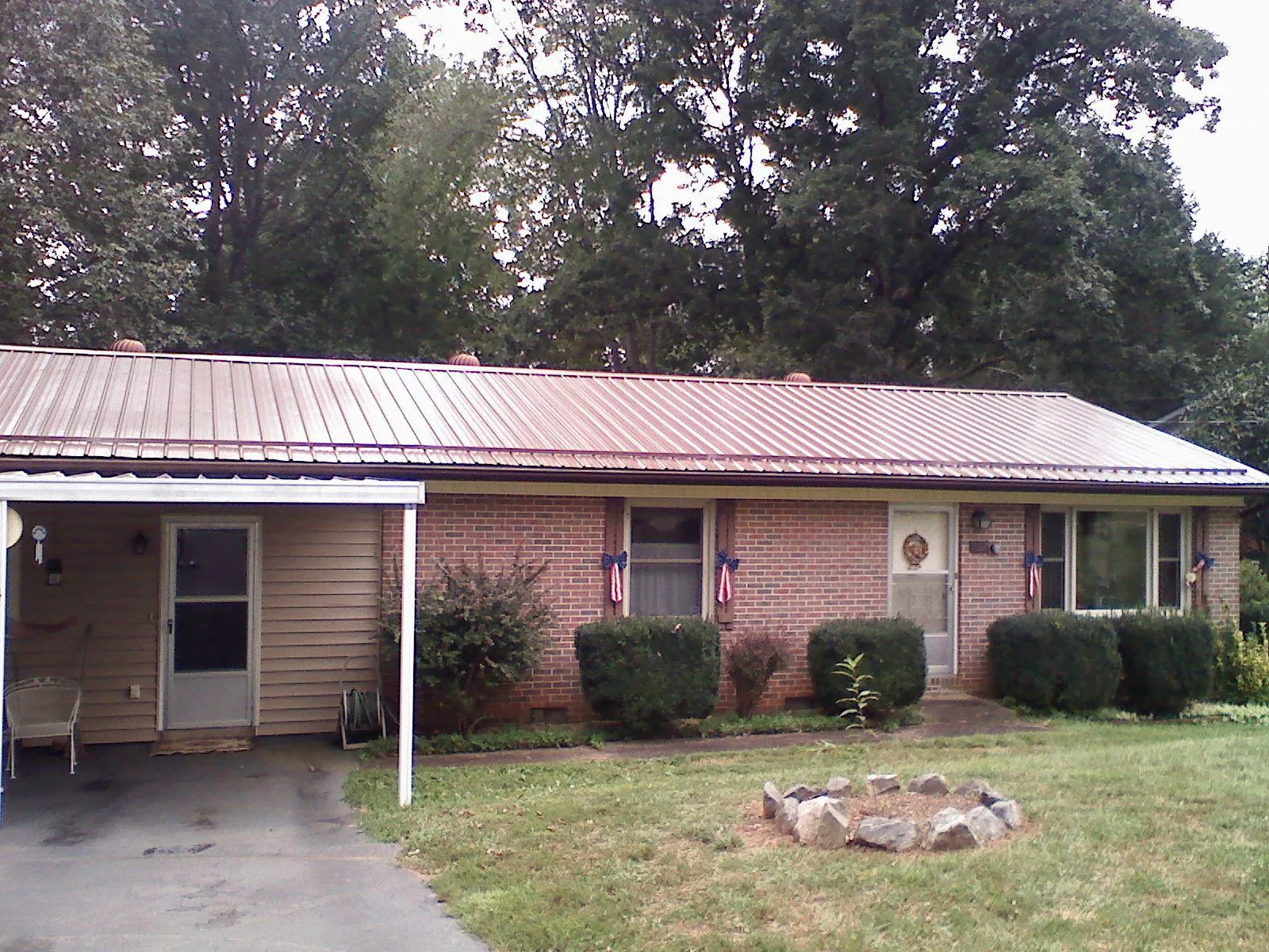 Bronze metal roof and carport on a brick ranch home — Roof Repair work by our crew in Le Sueur